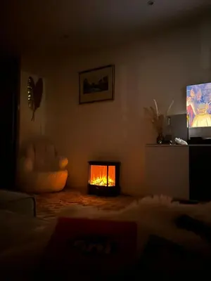 a living room with a fire in the fireplace at Appartement luxe Jaccuzi marbre et terrasse in Cannes