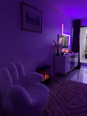 a purple living room with a chair and a television at Appartement luxe Jaccuzi marbre et terrasse in Cannes