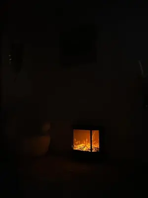 a dark room with a fire in a window at Appartement luxe Jaccuzi marbre et terrasse in Cannes