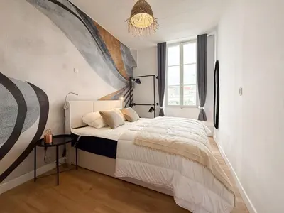 a bedroom with a bed and a chandelier at Stylish 3-Bedroom Cannes Apartment - Steps from Palais des Festivals in Cannes