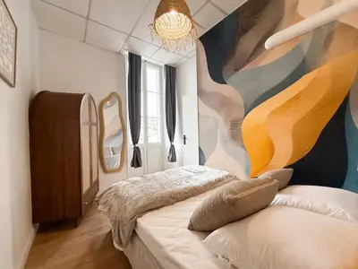 a bedroom with a large painting on the wall at Stylish 3-Bedroom Cannes Apartment - Steps from Palais des Festivals in Cannes