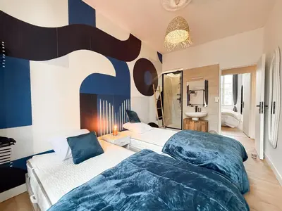 two beds in a bedroom with blue and white at Stylish 3-Bedroom Cannes Apartment - Steps from Palais des Festivals in Cannes