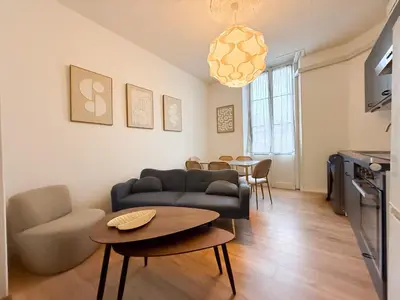 a living room with a couch and a table at Stylish 3-Bedroom Cannes Apartment - Steps from Palais des Festivals in Cannes