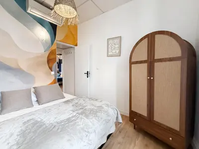 a bedroom with a bed and a wooden cabinet at Stylish 3-Bedroom Cannes Apartment - Steps from Palais des Festivals in Cannes