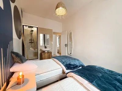 a bedroom with a bed and a bathroom with a sink at Stylish 3-Bedroom Cannes Apartment - Steps from Palais des Festivals in Cannes