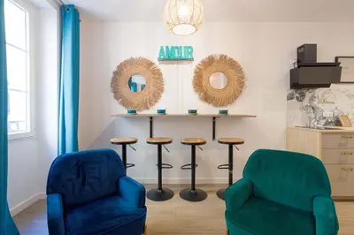 two chairs and a table in a room with mirrors at Majopi 2 - Central, AC, close to Palais & beaches in Cannes