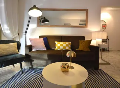 a living room with a couch and a table at Wiosna- Quiet 1 Bedroom in Cannes