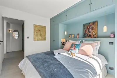 a bedroom with a large bed with blue walls at REF 2037 - Apartment for Rent Sea View in Cannes