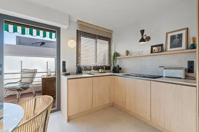 a kitchen with wooden cabinets and a table and a window at REF 2037 - Apartment for Rent Sea View in Cannes