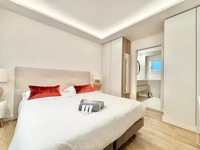 a bedroom with a large white bed with red pillows at Cannes 2 bedrooms & 2 bathrooms apartment - 24P2 in Cannes