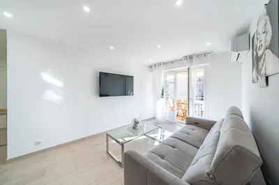 a living room with a couch and a tv at 3 pièces rénové en bord de mer - Terrasse in Cannes