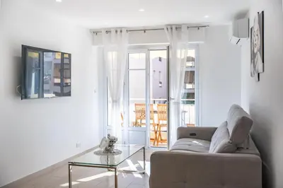 a living room with a couch and a glass table at 3 pièces rénové en bord de mer - Terrasse in Cannes