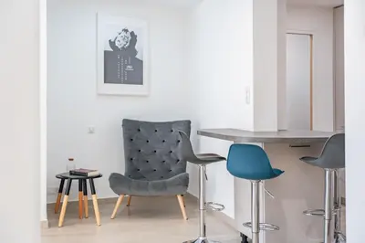 a living room with a chair and a table at 3 pièces rénové en bord de mer - Terrasse in Cannes