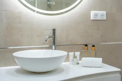 a bathroom with a white sink and a mirror at 3 pièces rénové en bord de mer - Terrasse in Cannes
