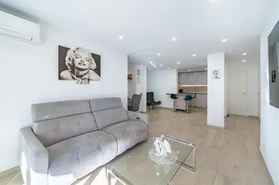 a living room with a couch and a glass table at 3 pièces rénové en bord de mer - Terrasse in Cannes