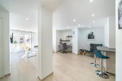a living room and dining room with a table and chairs at 3 pièces rénové en bord de mer - Terrasse in Cannes