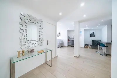 a living room with a glass table and a white wall at 3 pièces rénové en bord de mer - Terrasse in Cannes