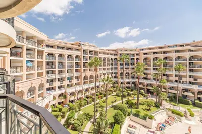 an apartment building with a courtyard with palm trees at Sea Cocoon La Bocca in Cannes