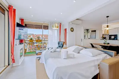 a bedroom with a large white bed and a kitchen at Jardin d'Eden - Incroyable Rooftop Jardin suspendu in Cannes