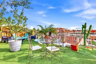 a patio with a table and chairs on grass at Jardin d'Eden - Incroyable Rooftop Jardin suspendu in Cannes