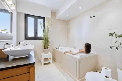 a bathroom with a sink and a tub and a mirror at Septieme Ciel - Exceptionnel Appartement vue Mer in Cannes