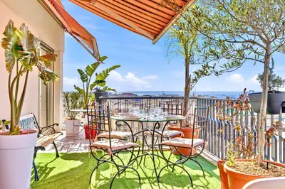 a living room with a blue couch and a table at Septieme Ciel - Exceptionnel Appartement vue Mer in Cannes