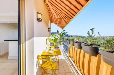 a kitchen with a counter and two stools at Septieme Ciel - Exceptionnel Appartement vue Mer in Cannes