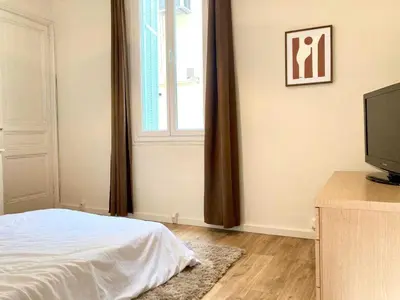 a bedroom with a bed and a window and a television at Appartement moderne - 1BR-4P- Cannes in Cannes