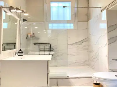 a white bathroom with a shower and a sink at Appartement moderne - 1BR-4P- Cannes in Cannes