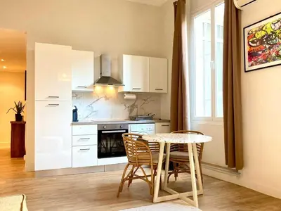 a kitchen with a table and a table and chairs at Appartement moderne - 1BR-4P- Cannes in Cannes