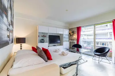 a bedroom with a large bed and a tv at Cozy studio in the heart of Cannes - Near sea in Cannes
