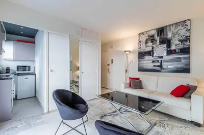 a living room with a white couch and a chair at Cozy studio in the heart of Cannes - Near sea in Cannes