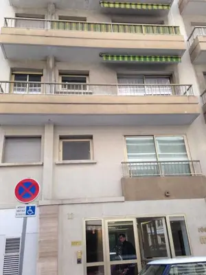 a tall building with a man sitting in a window at Cozy studio in the heart of Cannes - Near sea in Cannes