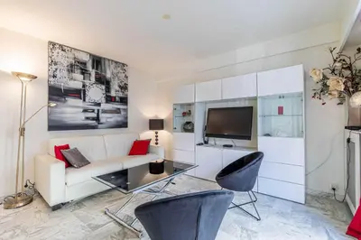 a living room with a white couch and a tv at Cozy studio in the heart of Cannes - Near sea in Cannes