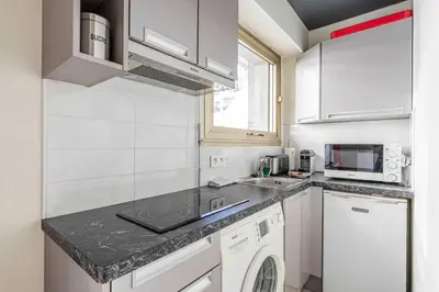 a white kitchen with a sink and a dishwasher at Cozy studio in the heart of Cannes - Near sea in Cannes
