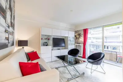 a living room with a couch and chairs and a tv at Cozy studio in the heart of Cannes - Near sea in Cannes