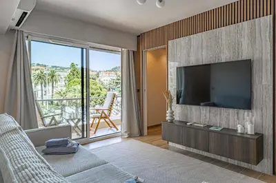 a living room with a large television and a balcony at Apartment for 4people in Martinez in Cannes