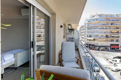 a balcony with a bed and a chair and a building at Apartment for 4people in Martinez in Cannes
