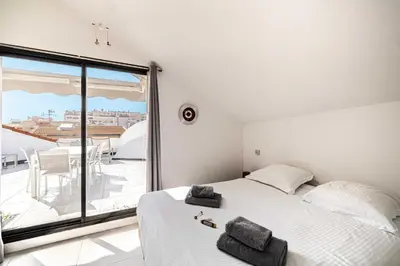a bedroom with a bed and a large window at Luxury Penthouse 120mÂ² in the heart of Cannes in Cannes