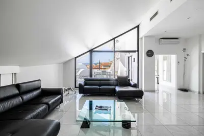a living room with black leather furniture and a glass table at Luxury Penthouse 120mÂ² in the heart of Cannes in Cannes