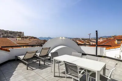 a patio with a table and chairs on a roof at Luxury Penthouse 120mÂ² in the heart of Cannes in Cannes