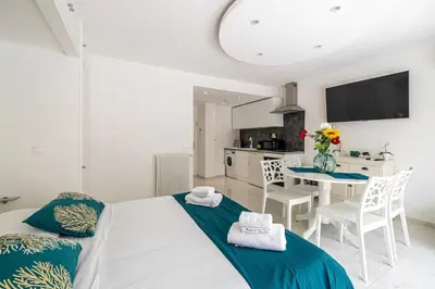 a bedroom with a bed and a table with chairs at Charming studio near the Croisette in Cannes