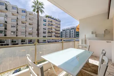 a table and chairs on a balcony with a view of buildings at Charming studio near the Croisette in Cannes