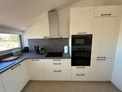 a kitchen with white cabinets and a stove top oven at Roof top Luxe Cannes in Cannes