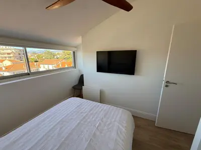a bedroom with a bed and a flat screen tv at Roof top Luxe Cannes in Cannes