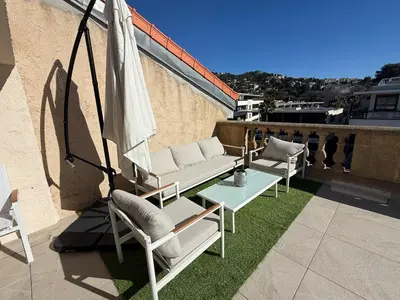 a patio with two chairs and a table and an umbrella at Roof top Luxe Cannes in Cannes