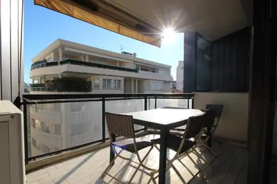 a balcony with a table and chairs and a building at PROCHE CARLTON One bedroom Apartment in Cannes