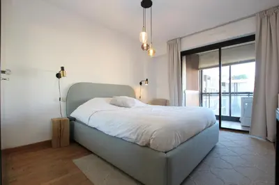 a bedroom with a bed and a large window at PROCHE CARLTON One bedroom Apartment in Cannes