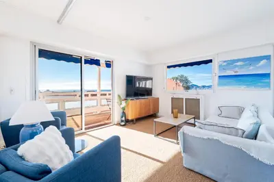 a living room with blue furniture and a view of the ocean at Marius By Terrys Homes in Cannes