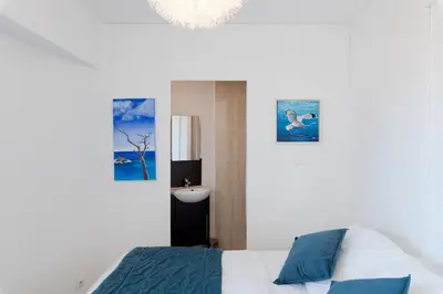 a bedroom with a bed and two pictures on the wall at Marius By Terrys Homes in Cannes